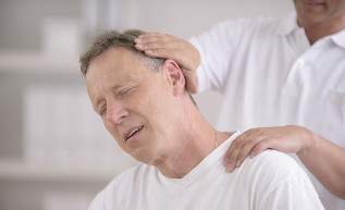 A man with osteochondrosis of the neck in consultation with a hand masseur